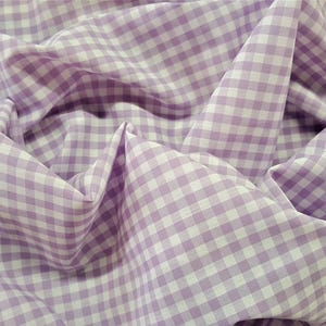May include: A close-up of a purple and white gingham fabric. The fabric is folded and wrinkled, showing the texture of the material.