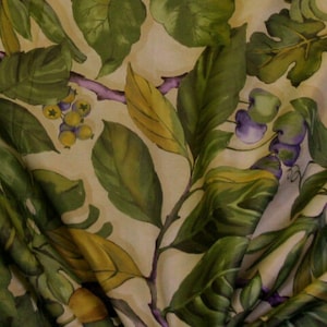 May include: A beige fabric with a green, yellow, and purple floral pattern. The fabric features a repeating pattern of leaves, berries, and vines.