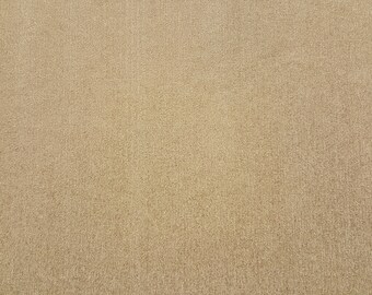 May include: A close-up of a beige textured surface. The surface has a fine grain and a slightly rough texture.