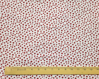 May include: White fabric covered in a pattern of small, red stars. A wooden ruler with inch markings is at the bottom of the image, measuring up to 14 inches.