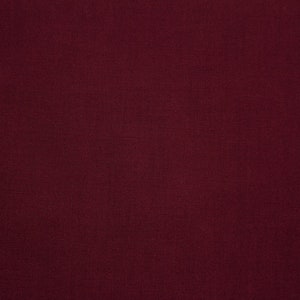 May include: A solid, deep burgundy fabric with a subtle texture. The fabric is smooth and appears to be woven.