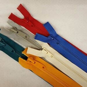 May include: Five different colored zippers with plastic sliders. The zippers are red, blue, beige, green, and yellow.