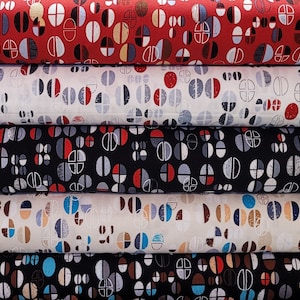 May include: A stack of five fabric rolls with a geometric pattern of red, black, white, blue, and brown circles and semi-circles.