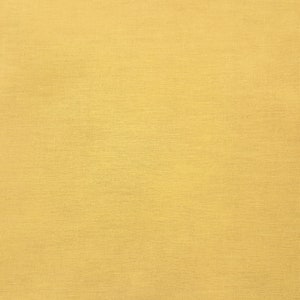 May include: A full shot of a solid, golden-yellow fabric. The material has a subtle, textured appearance, with a slightly uneven surface. The color is consistent across the entire frame, creating a simple, yet visually appealing backdrop.