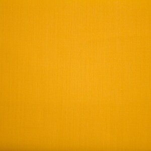 May include: A solid yellow fabric background.