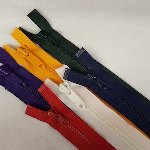 May include: Five different colored zippers, including red, white, purple, yellow, and dark blue.