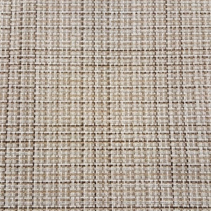 May include: A close-up of a woven brown and white placemat with a textured surface.