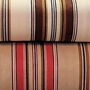 May include: Two rolls of striped fabric, one with brown and white stripes and the other with red and white stripes.