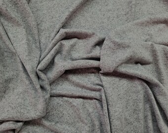 May include: A close-up shot of a gray fabric with a speckled texture. The fabric is draped and folded, creating shadows and depth. The material appears soft and possibly suitable for clothing or home decor.