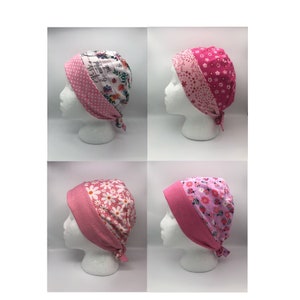May include: Four pink and white patterned surgical caps with ties. The caps are made of soft, breathable fabric and are designed to be comfortable to wear. The caps are perfect for medical professionals, nurses, and other healthcare workers.