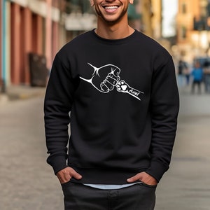 May include: Black sweatshirt with a white graphic of a human hand and a dog paw bumping fists. The text "Axel" is below the graphic.