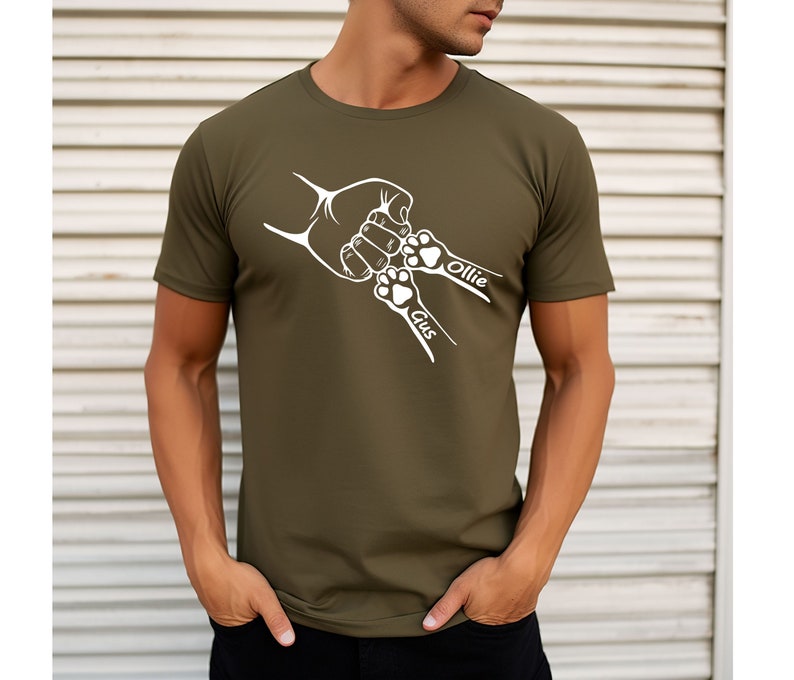May include: A green t-shirt with a white design of a hand and two paw prints. The paw prints have the names "Gus" and "Ollie" written next to them.