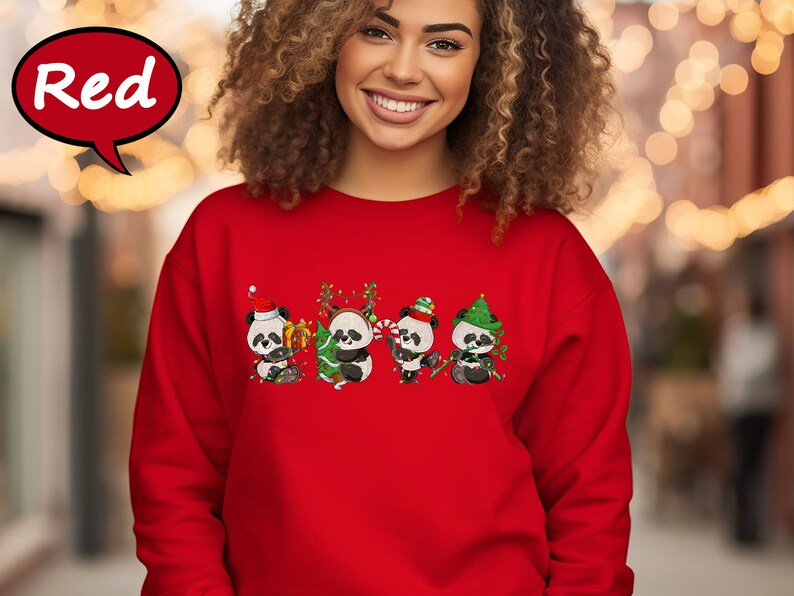 May include: Red Christmas sweatshirt featuring four adorable pandas wearing Santa hats and holding Christmas decorations. The pandas are surrounded by Christmas lights and a Christmas tree.