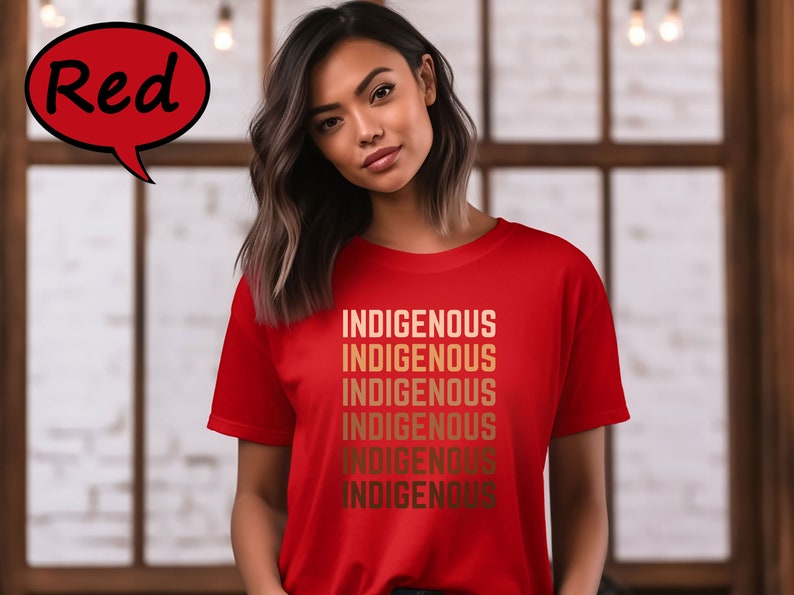Pu&ograve; includere: Una maglietta rossa con la parola "INDIGENOUS" stampata pi&ugrave; volte in una sfumatura di colori oro. La maglietta &egrave; indossata da una persona. La parola "Red" &egrave; in un fumetto rosso in alto a sinistra.