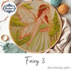 May include: Hand embroidery pattern featuring a fairy with red hair, a green dress, and large wings. The design is set in a wooden embroidery hoop. The text "Fairy 3" and "Hand embroidery pattern" are visible.