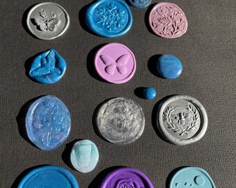 May include: Assortment of wax seals in various colors and designs, including butterflies, flowers, birds, and a bee. The seals are made of wax and have a shiny finish.