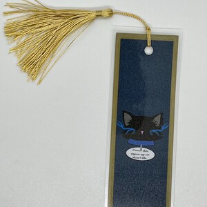 Peut inclure: Un marque-page bleu et or avec une illustration de chat noir et le texte "Je ne sors jamais avec quelqu'un que mon chat n'aime pas". Le marque-page a un pompon doré.