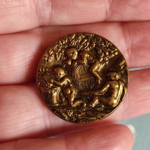 Antique brass picture button children of the bacchante