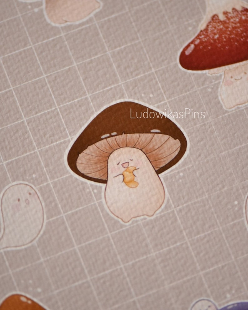 Puede incluir: Un hongo marr&oacute;n y blanco con una cara sonriente que sostiene un gusano amarillo y naranja. El hongo est&aacute; sobre un fondo de cuadr&iacute;cula marr&oacute;n claro. El texto "LudowikasPins" est&aacute; en la esquina superior derecha de la imagen.