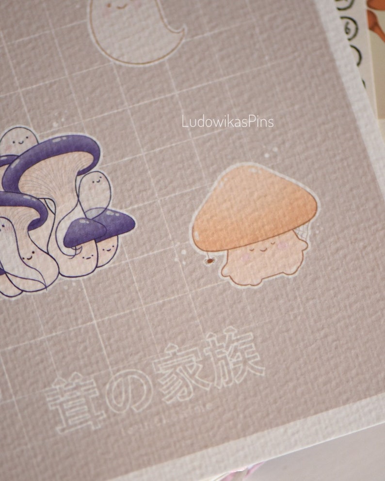 Puede incluir: Un hongo marr&oacute;n claro con un tallo blanco y una cara sonriente. El hongo est&aacute; sobre un fondo marr&oacute;n claro con un patr&oacute;n de cuadr&iacute;cula. El texto "LudowikasPins" est&aacute; en la esquina superior derecha de la imagen. El texto "春の家族" est&aacute; en el centro inferior de la imagen.