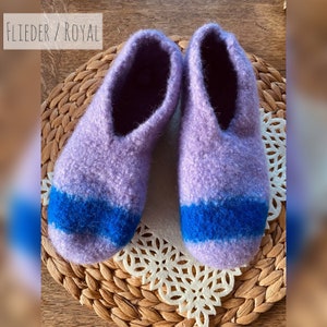 May include: Purple and blue knitted slippers with a fluffy texture. The slippers have a blue stripe across the top.