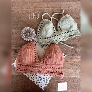 Peut inclure: Deux hauts en crochet faits &agrave; la main. L'un est de couleur rose poudr&eacute;, l'autre vert clair. Les deux hauts ont un bord festonn&eacute; et un design dos nu. Le mot "LIND" est &eacute;crit dans l'image.