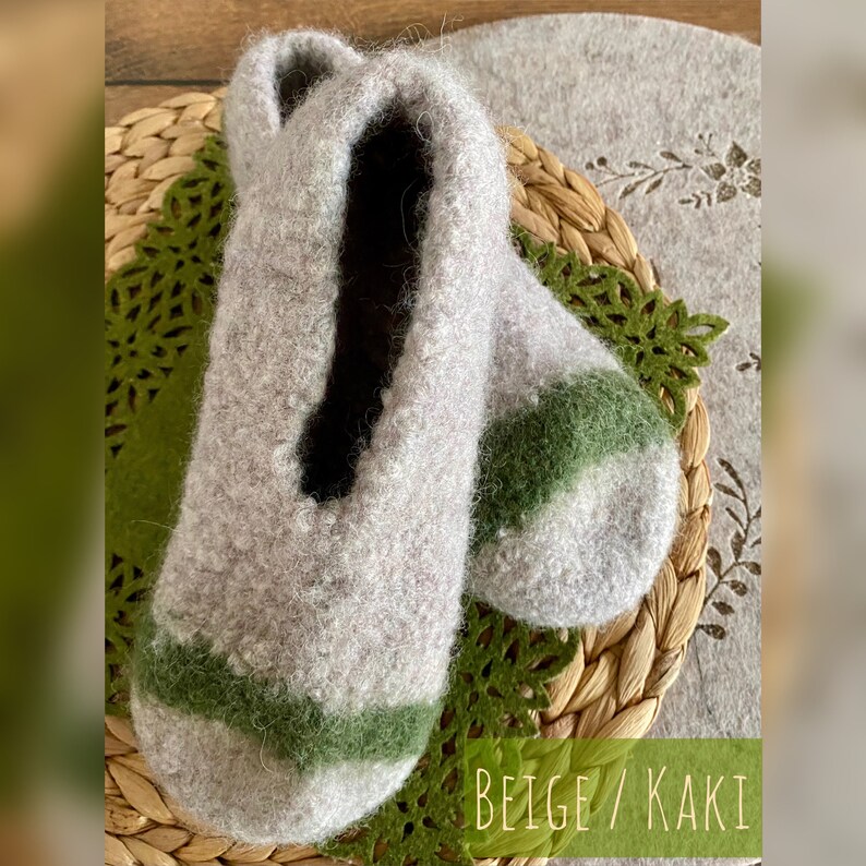 May include: Beige and green wool slippers with a contrasting stripe. The slippers are soft and cozy, perfect for keeping your feet warm in the winter.