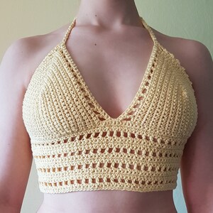 May include: A yellow crochet halter top with a V-neckline and a delicate openwork pattern.