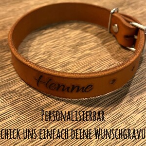 Op de afbeelding: Een bruine leren hondenriem met het woord "Hemme" erop gegraveerd. De riem is gepersonaliseerd en je kunt je eigen tekst toevoegen.