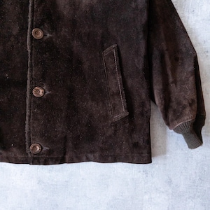 K&ouml;nnte beinhalten: Nahaufnahme einer braunen Wildlederjacke mit drei Kn&ouml;pfen und einer Tasche. Die Jacke hat eine gerippte Manschette am &Auml;rmel. Das Wildleder hat ein leicht abgenutztes Aussehen.