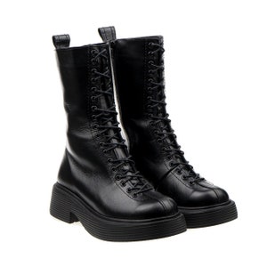 May include: A pair of black leather lace-up boots with chunky platform soles.