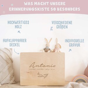 May include: A wooden memory box with a hinged lid, personalised with the name "Antonio" and birth details. The box is made of high-quality wood and has a natural finish. It is decorated with a small floral design. The box is sitting on a white surface with two stuffed bunny toys.