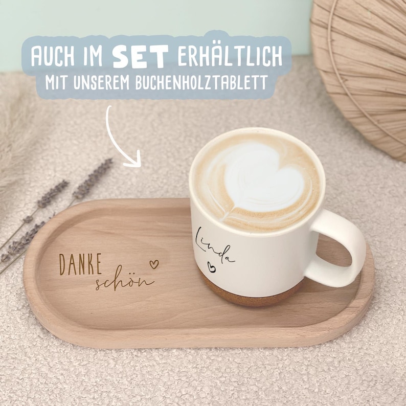 May include: A white ceramic mug with a heart-shaped latte art design, resting on a wooden tray. The tray has the words "Danke sch&ouml;n" and a heart etched into the wood. The mug is personalized with the name "Linda".
