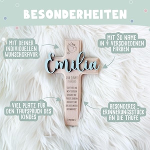 May include: A wooden cross with a dove and the name "Emilia" in blue lettering. The cross is decorated with a quote about faith and the date "21.08.2023". It is a personalized baptism gift.