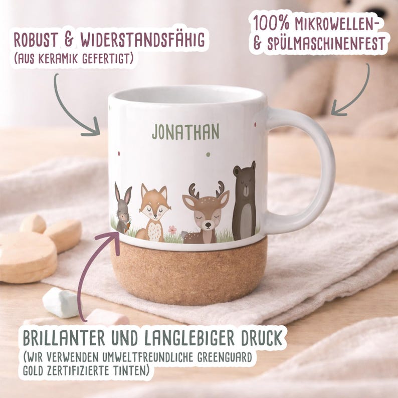 May include: White ceramic mug with a cork base, featuring woodland animal illustrations and the name "JONATHAN" in green. The mug is decorated with a rabbit, fox, deer, and bear. The mug is microwave and dishwasher safe.