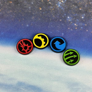 Könnte beinhalten: Vier runde Token mit verschiedenen Symbolen und Farben. Die Token sind schwarz mit roten, gelben, blauen und grünen Symbolen. Die Symbole sind eine Sternform, ein Zahnrad, ein Pfeil, der nach oben und rechts zeigt, und drei Pfeile, die nach rechts zeigen.