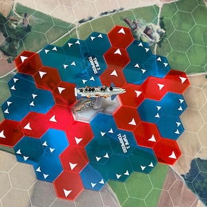 以下が含まれることがあります： 海軍をテーマにしたボードゲーム。ゲーム盤は、赤と青のタイルで構成された六角形のグリッドです。ミニチュアの軍艦が中央に配置されています。「TYPE 1 TORPEDO」の文字が見えます。