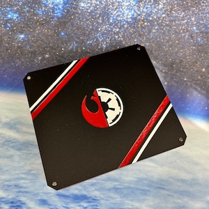 May include: A black metal plate with a red and white stripe design. The plate features a split symbol, half Rebel Alliance and half Imperial, in red and white.