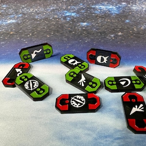 May include: A collection of black, red, and green game tokens with white symbols. The tokens are rectangular with rounded edges. The symbols include arrows, curved lines, and geometric shapes. The background is a blurred image of a starry sky.
