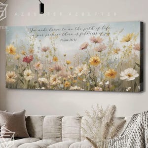 May include: A canvas wall art print featuring a watercolor painting of a field of flowers in shades of pink, yellow, and white. The print includes the text "You make known to me the path of life, in your presence there is fullness of joy. Psalm 16:11."