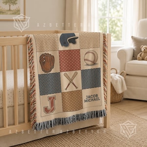 May include: A woven throw blanket featuring a baseball theme with a grid pattern of icons including a helmet, glove, ball, and crossed bats. The design incorporates the letter J and the name Jacob Michael in a tan, brown, and navy color palette.