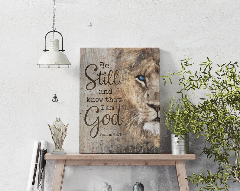 Puede incluir: Una impresi&oacute;n en lienzo con la cara de un le&oacute;n y las palabras "Be Still and know that I am God" con la referencia b&iacute;blica "Salmo 46:10" debajo.