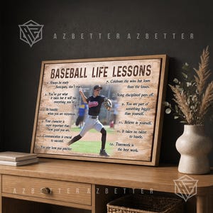 May include: A rectangular framed wall art piece titled BASEBALL LIFE LESSONS featuring a photograph of a baseball player in a dark jersey and light pants on a field, surrounded by twelve numbered motivational quotes printed on a wood-grain background.