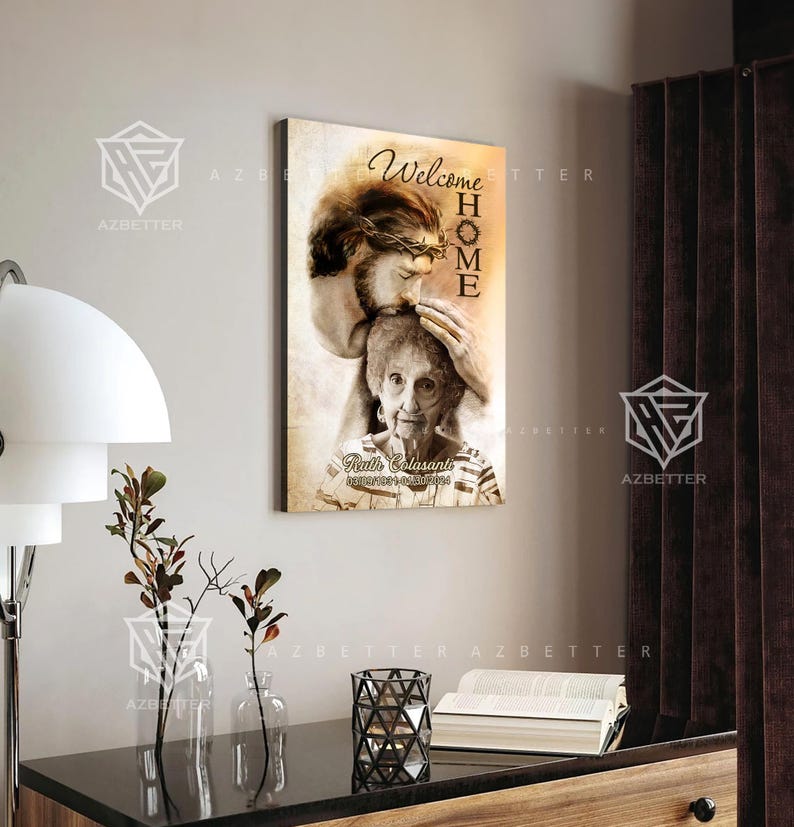 May include: A sepia-toned canvas print featuring a drawing of Jesus with a crown of thorns, holding a woman in his arms. The text "Welcome Home" is written in a decorative font above them. The woman's name and dates are written below the image.