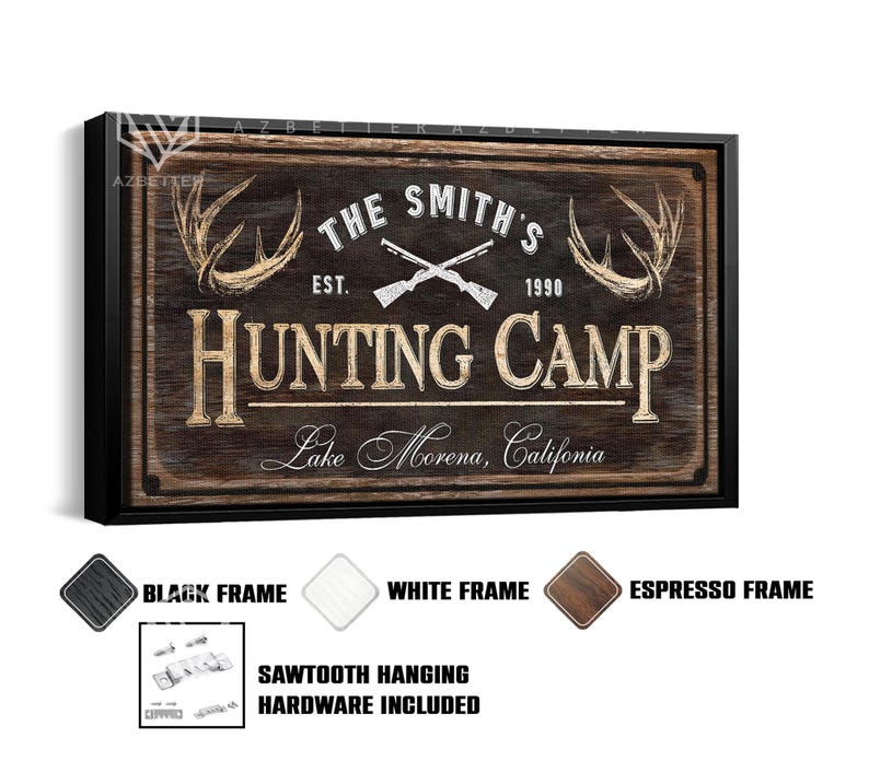 May include: A framed wooden sign with the text "THE SMITH'S HUNTING CAMP" and the location "Lake Morena, California." The sign features crossed rifles, deer antlers, and the year "1990." Available in black, white, and espresso frames. Sawtooth hanging hardware included.