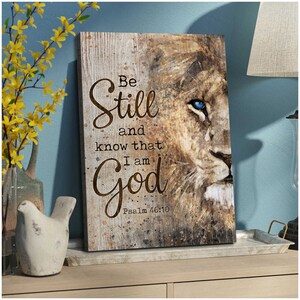 Puede incluir: Una impresi&oacute;n en lienzo con la cara de un le&oacute;n y las palabras "Be Still and know that I am God" con la referencia b&iacute;blica "Salmo 46:10".