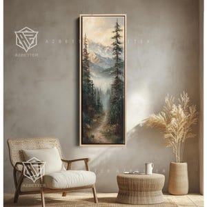 May include: Vertical framed landscape painting depicting a forest path leading towards mountains. The artwork features tall evergreen trees, a misty atmosphere, and a muted color palette of greens, browns, and blues. The frame is a light wood color. The text "AZBETTER" is visible.