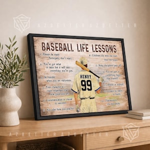 May include: Framed artwork with the text "Baseball Life Lessons" and a baseball player illustration. The artwork features a baseball player with the name "Henry" and the number "99" on the back of his jersey. The artwork is displayed on a wooden table.