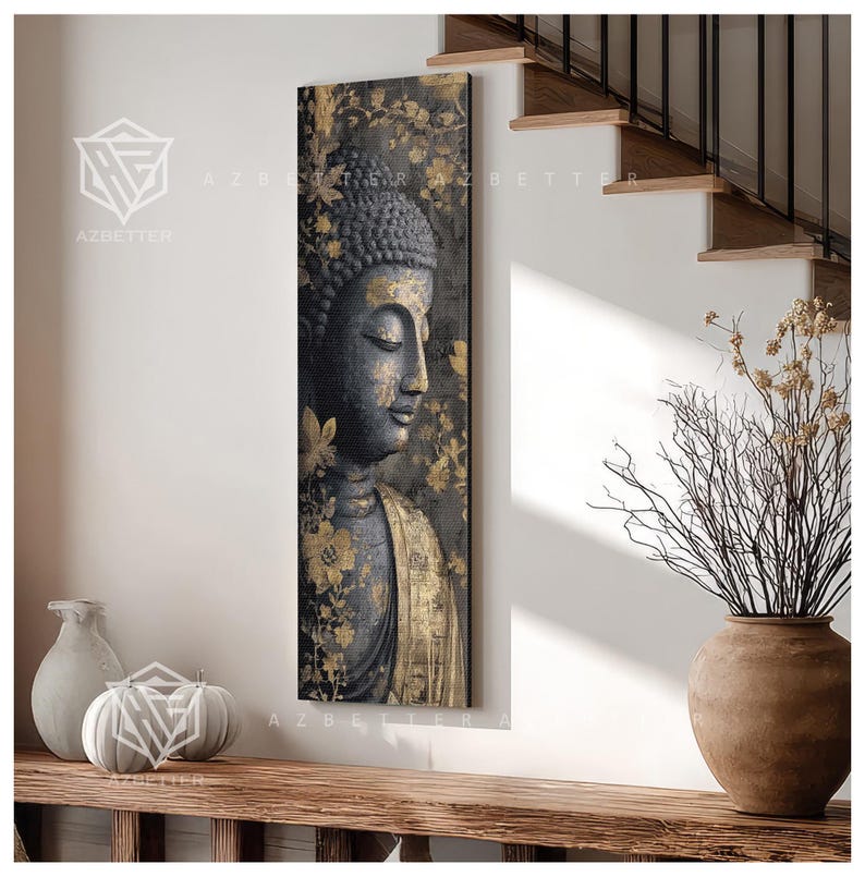 May include: A vertical canvas print featuring a serene Buddha image. The artwork showcases a dark gray Buddha with gold accents, set against a backdrop of gold floral patterns. The print is displayed on a white wall near a wooden shelf.
