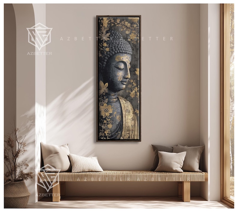 May include: A framed vertical artwork featuring a serene Buddha statue with a dark gray complexion and gold accents. The artwork is adorned with gold floral patterns and is displayed above a woven bench with neutral-colored pillows.